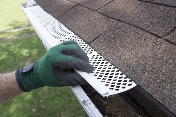 Contractor Adjusting Plastic Gutter Guards Contractor Adjusting Plastic Gutter Guards